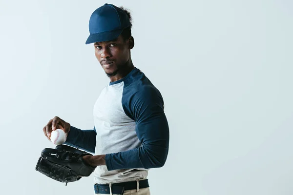 Уверенный в себе американский спортсмен в бейсбольной перчатке, смотрящий в камеру, изолированную на сером — стоковое фото