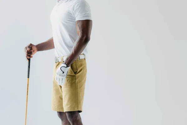 Vista recortada del deportista afroamericano sosteniendo club de golf aislado en gris - foto de stock