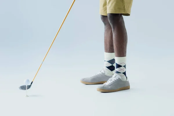 Cropped view of african american sportsman playing golf on grey background — Stock Photo