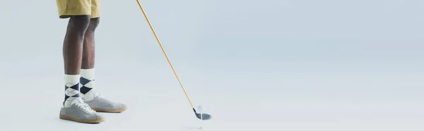 Partial view of african american sportsman playing golf on grey background, panoramic shot — Stock Photo