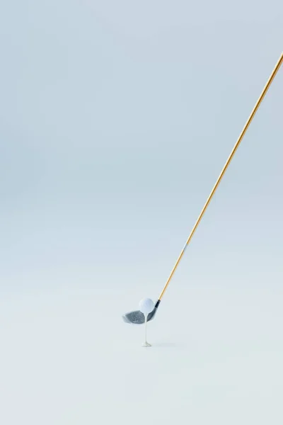 Golf club near golf ball on tee on grey background — Stock Photo