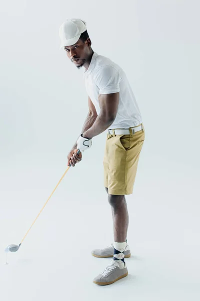 Bonito afro-americano desportista jogar golfe no fundo cinza — Fotografia de Stock