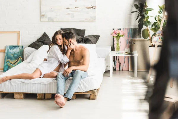 Вибірковий фокус пари обіймається, сидячи в спальні — стокове фото