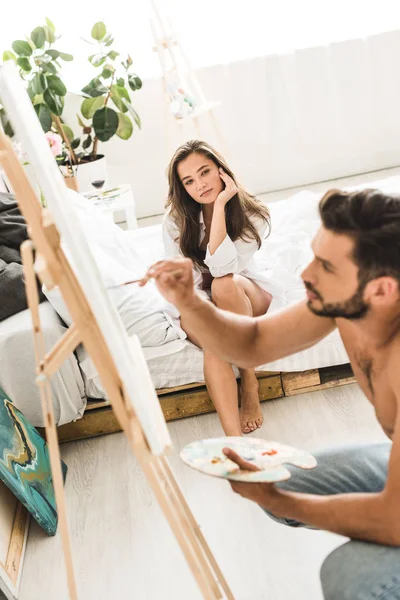 Selective focus of sext man drawing while young girl looking at guy — Stock Photo