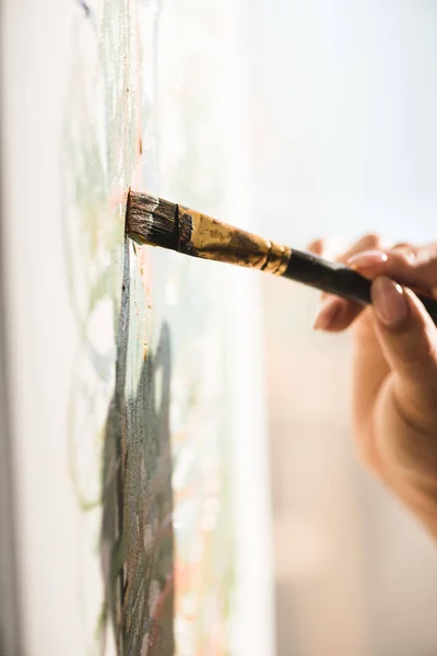 Cropped view of girl drawing with green paint and brush — Stock Photo