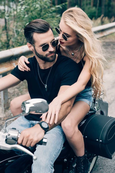 Jovem casal de motociclistas abraçando de perto na motocicleta preta — Fotografia de Stock