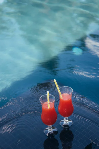 Dois copos com bebida refrescante de frutas naturais à beira da piscina — Fotografia de Stock