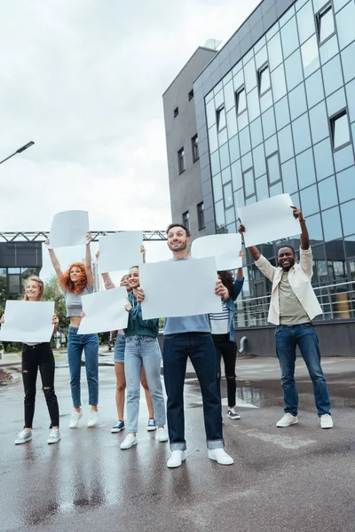 Happy multicultural people holding blank placards on street — Stock Photo
