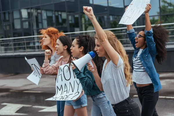 Selektiver Fokus von Mädchen, die gestikulieren, während sie beim Treffen ein Megafon in der Nähe multikultureller Frauen halten — Stockfoto