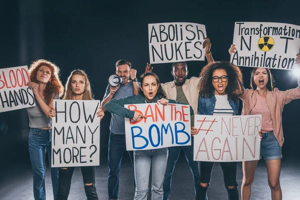 Hombres y mujeres emocionales multiculturales con pancartas en negro - foto de stock