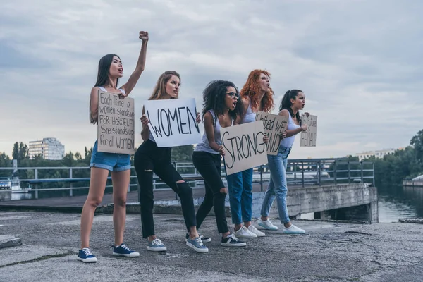 Emotive ragazze multiculturali che tengono cartelli e urlano fuori — Foto stock