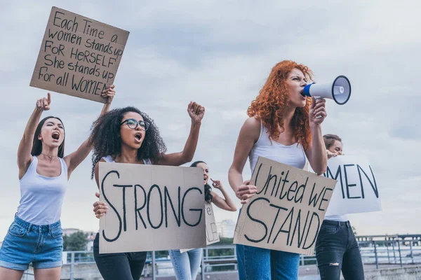 Мультикультурные девушки держат плакаты и кричат снаружи — стоковое фото