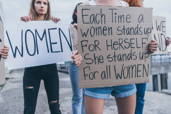 Selective focus of girl holding placard with each time a women stands up for herself sh stands up for all women letters — Stock Photo