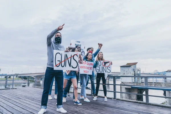 Personas multiculturales que sostienen pancartas con letras mientras hacen gestos en el puente - foto de stock