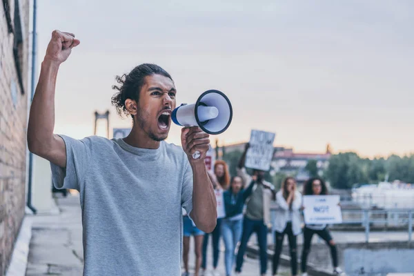 Selektiver Fokus eines afrikanisch-amerikanischen Mannes, der schreit, während er ein Megafon hält — Stockfoto