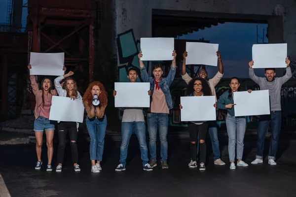 Emotional multicultural young people holding blank placards on meeting — Stock Photo
