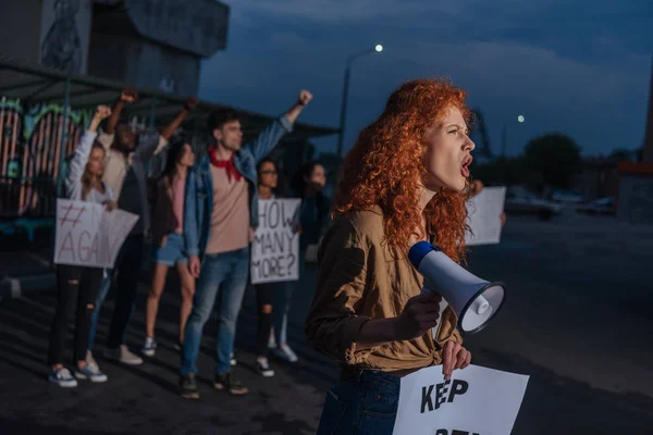 Selective focus of curly redhead girl holding placard and screaming on meeting — Stock Photo