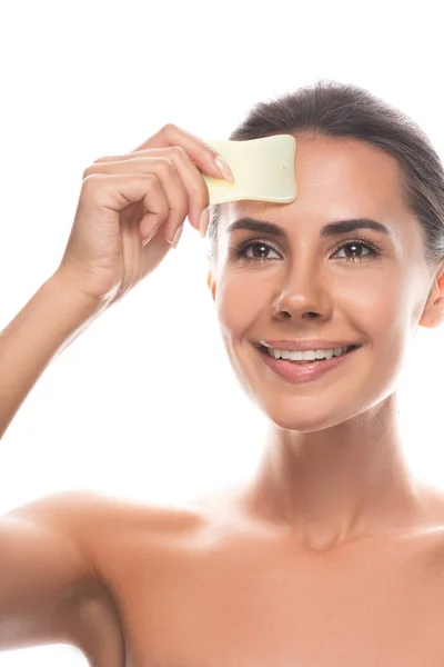 Nu sourire jeune femme en utilisant gua sha grattoir isolé sur blanc — Photo de stock