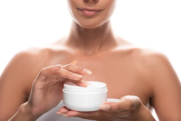 Vista recortada de la mujer joven sosteniendo crema cosmética aislado en blanco - foto de stock