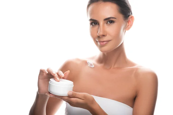 Attractive young woman holding cosmetic cream isolated on white — Stock Photo