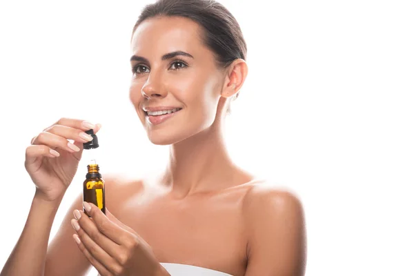 Smiling young woman holding serum isolated on white — Stock Photo
