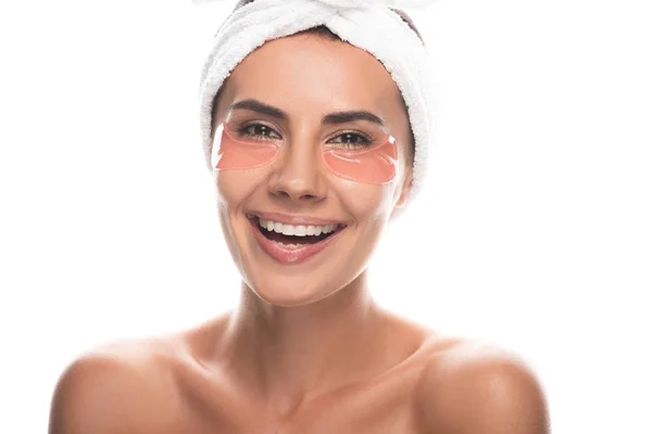 Vue de face de jeune femme nue en bande capillaire cosmétique avec des bandeaux oculaires souriant isolé sur blanc — Photo de stock