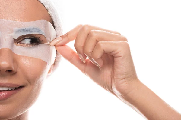Vue partielle de jeune femme nue en bande capillaire cosmétique avec masque facial souriant isolé sur blanc — Photo de stock