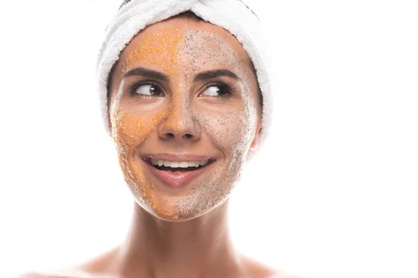 Vue de face de jeune femme excitée dans la bande capillaire cosmétique avec gommage sur le visage isolé sur blanc — Photo de stock