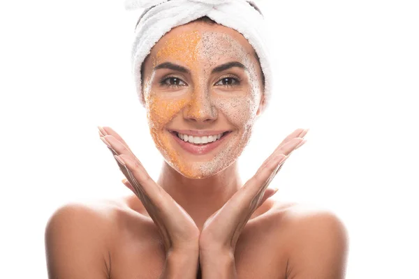 Vista frontal de mujer joven excitada en banda de pelo cosmético con exfoliante en la cara aislado en blanco - foto de stock