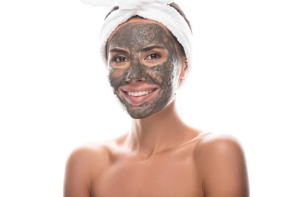 Jeune femme nue en bande capillaire cosmétique avec masque en argile sur le visage isolé sur blanc — Photo de stock