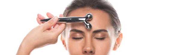 Tiro panorâmico de massagista usando massageador facial isolado em branco — Fotografia de Stock