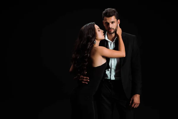 Leidenschaftliches Mädchen im Kleid berührt gutaussehenden bärtigen Mann isoliert auf schwarz — Stockfoto