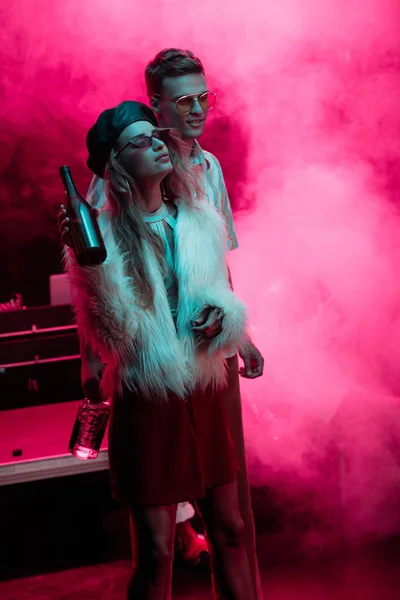 Schöne junge Frau mit Bier und Mann in Nachtclub während Rave — Stockfoto