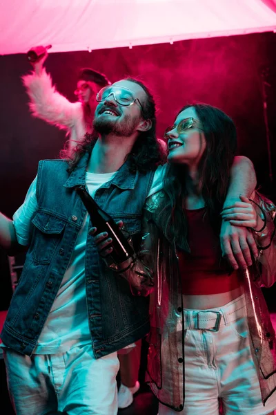 Sourire belle jeune femme avec de la bière et l'homme en boîte de nuit pendant la rave — Photo de stock