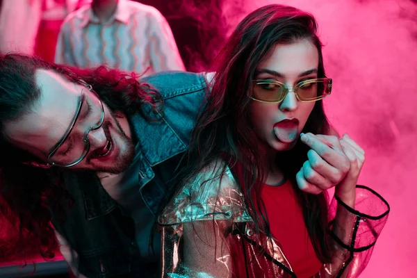 Hombre poniendo en lengua de mujer lsd píldora en discoteca — Stock Photo