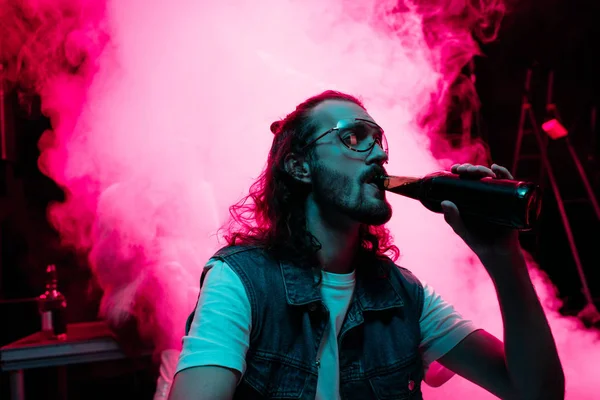 Hombre en gafas de sol beber alcohol durante rave en discoteca — Stock Photo