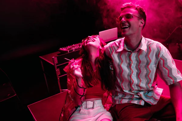 Man and young woman laughing during rave party in nightclub — Stock Photo
