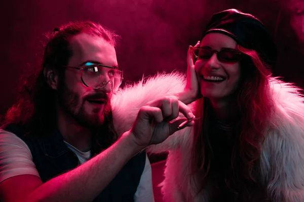 Hombre dando marihuana conjunta a sonriente chica en nightclub - foto de stock