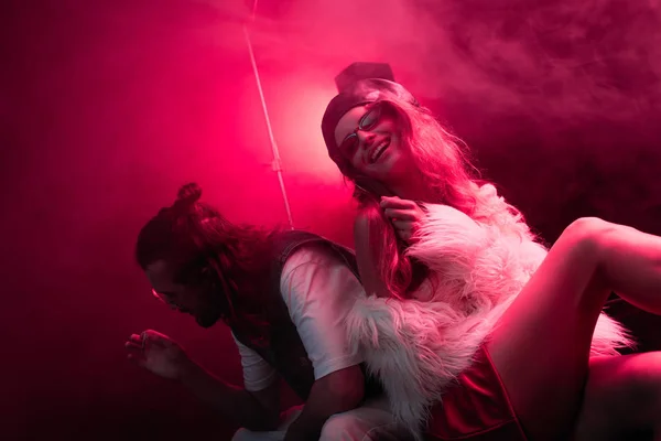 Mann mit Zigarette sitzt bei Rave-Party in Nachtclub neben glücklichem Mädchen — Stockfoto
