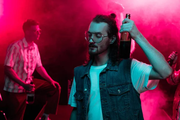 Homem segurando cerveja na boate e dançando durante rave — Fotografia de Stock