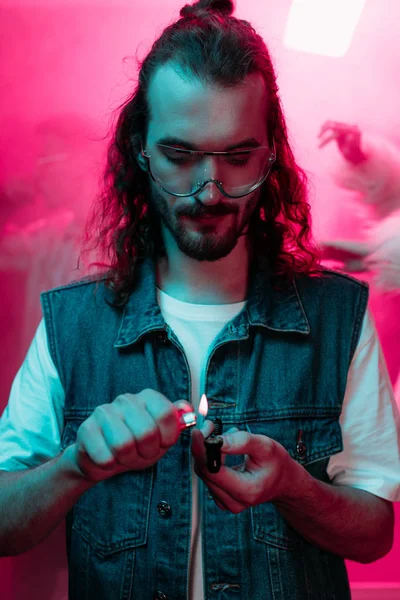 Schöner Mann zündet Pfeife mit Marihuana in Nachtclub an — Stockfoto
