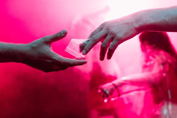 Cropped view of man passing drugs in plastic zipper bag to man in nightclub — Stock Photo