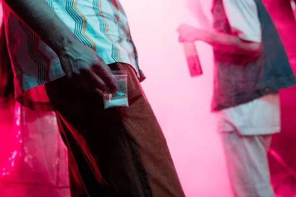 Man holding drugs in plastic zipper bag in nightclub with copy space — Stock Photo