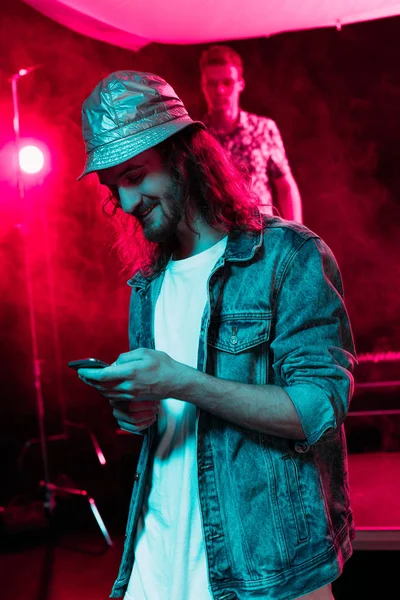 Homme utilisant smartphone pendant la fête rave dans la boîte de nuit — Photo de stock