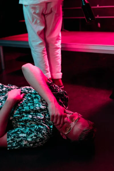 Kranker Mann liegt in Nachtclub auf dem Boden und deckt Mund mit Hand zu — Stockfoto