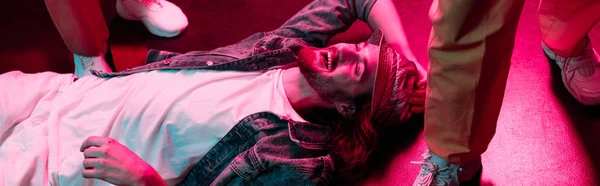 Panoramic shot of smiling man lying on floor in nightclub — Stock Photo