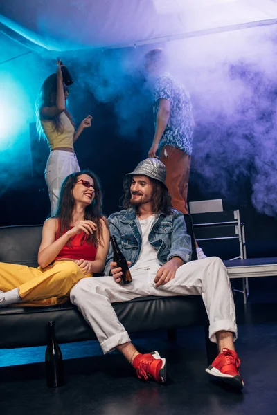 Homme avec de l'alcool et fille assis sur le canapé dans la boîte de nuit — Photo de stock