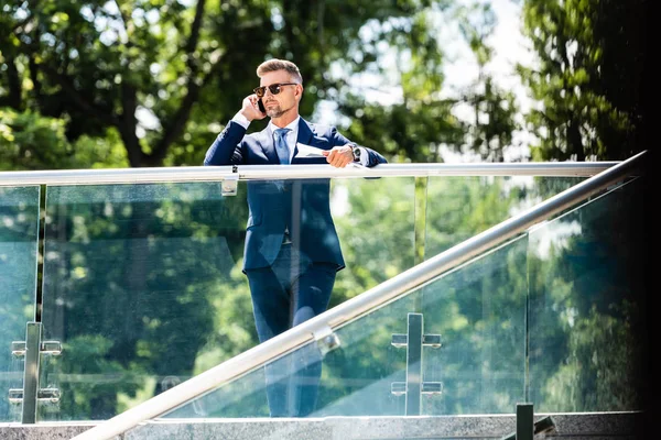 Schöner Geschäftsmann in Anzug und Brille, der auf dem Smartphone spricht — Stockfoto