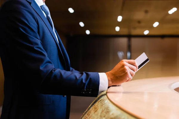 Cropped view of businessman in suit giving credit card — Stock Photo