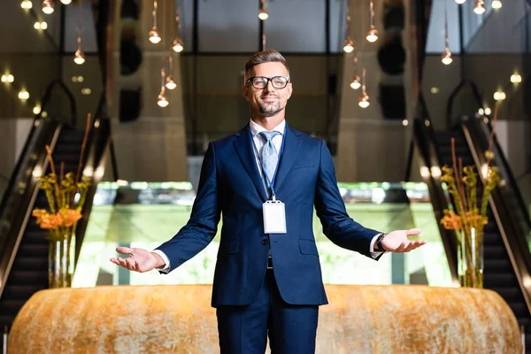 Schöner Geschäftsmann in Anzug und Brille mit ausgestreckten Händen — Stockfoto